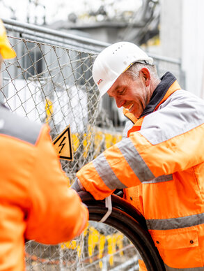 Zwei Ploier + Hörmann Mitarbeiter arbeiten lachend auf einer Baustelle
